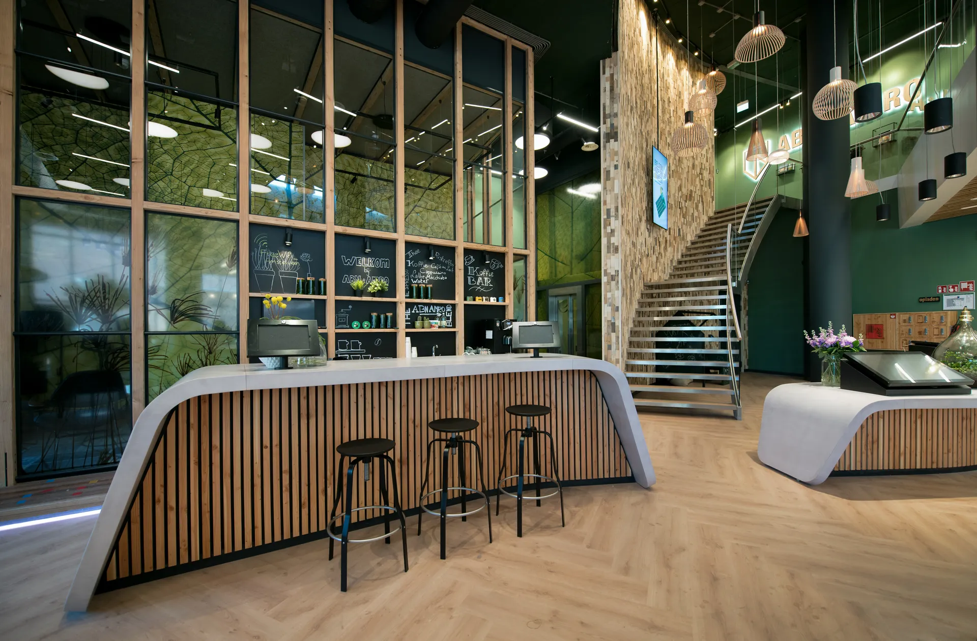 Een moderne receptieruimte in een kantoor met een strakke, ronde balie en een glazen wand met uitzicht naar buiten.