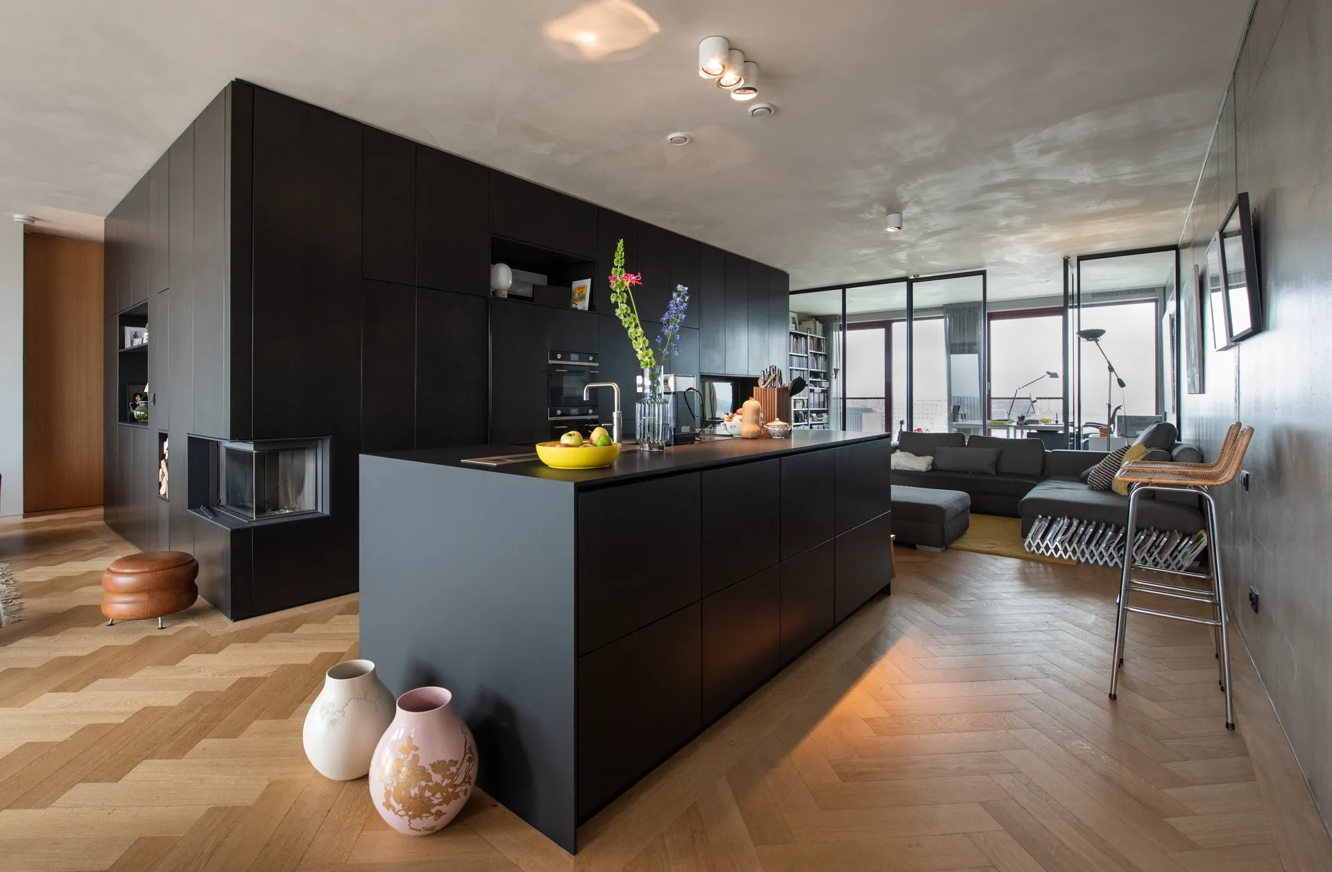 Een moderne woonkamer of lounge met donkere stijlvolle muren, een groot raam en een comfortabele zitgroep voor rust.